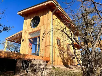 a wooden bird house with a clock on it at Mandala Tiny House, Traslasierra. in Yacanto