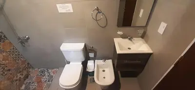 a small bathroom with a toilet and a sink at Gemas Apart in Villa Yacanto