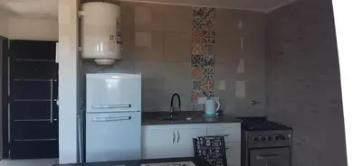 a kitchen with a white refrigerator and a sink at Gemas Apart in Villa Yacanto