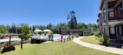 a yard with a swimming pool and a building at Gemas Apart in Villa Yacanto