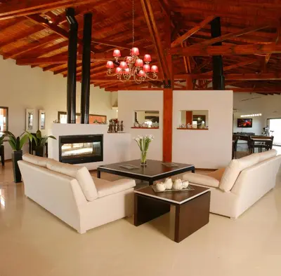 a living room with white furniture and a fireplace at Posada Loma del Tigre in Los Reartes