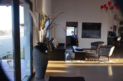 a living room with a vase with flowers in it at Posada Loma del Tigre in Los Reartes
