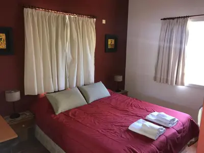 a bedroom with a red bed with towels on it at LA CASONA in Villa General Belgrano