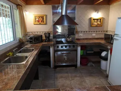 a kitchen with a stove and a sink at LA CASONA in Villa General Belgrano