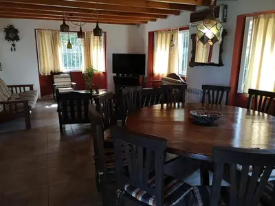 a dining room with a wooden table and chairs at LA CASONA in Villa General Belgrano