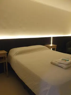 a white bed in a room with two tables at LOAN Nueva Cordoba 3i in Cordoba