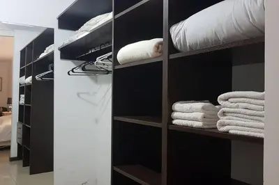 a closet with black shelves and white towels at LOAN Nueva Cordoba 3i in Cordoba
