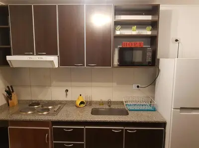a kitchen with a sink and a white refrigerator at LOAN Nueva Cordoba 3i in Cordoba