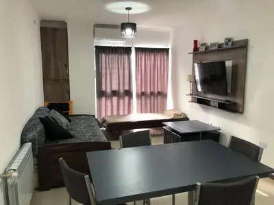 a living room with a couch and a table at Edificio Veneto IV - Departamento de un dormitorio en pleno centro in Villa Carlos Paz
