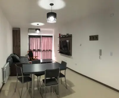 a living room with a black table and chairs at Edificio Veneto IV - Departamento de un dormitorio en pleno centro in Villa Carlos Paz
