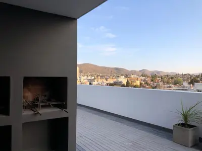 a living room with a fireplace and a view of a city at Edificio Veneto IV - Departamento de un dormitorio en pleno centro in Villa Carlos Paz