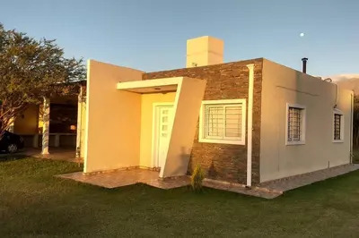 a house with a yellow door and a yard at Confortable casa traslasierra. Vista al Champaqui in Quebrada de los Pozos