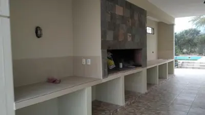a living room with a fireplace in a house at Confortable casa traslasierra. Vista al Champaqui in Quebrada de los Pozos