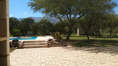a backyard with a swimming pool and trees at Confortable casa traslasierra. Vista al Champaqui in Quebrada de los Pozos
