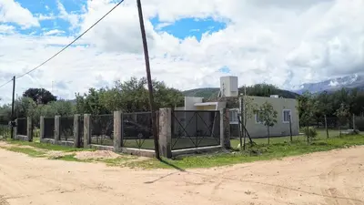 a fence on the side of a dirt road at Confortable casa traslasierra. Vista al Champaqui in Quebrada de los Pozos