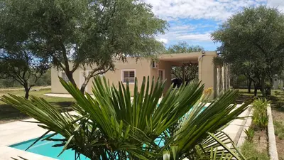 a house with a pool in front of it at Confortable casa traslasierra. Vista al Champaqui in Quebrada de los Pozos