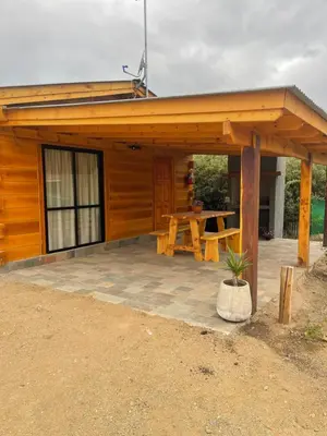 a wooden pavilion with a picnic table in front of it at Complejo Anthea in Villa Yacanto