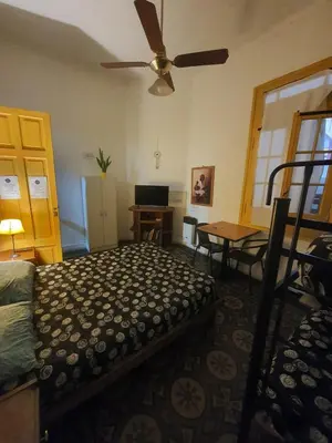 a bedroom with a bed and a ceiling fan at Morada Hostel & Bar in Cordoba
