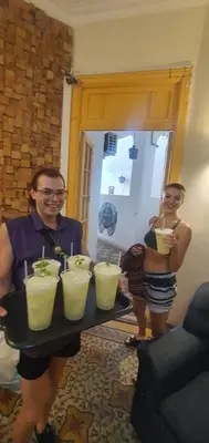 two people are holding a tray with four drinks at Morada Hostel & Bar in Cordoba