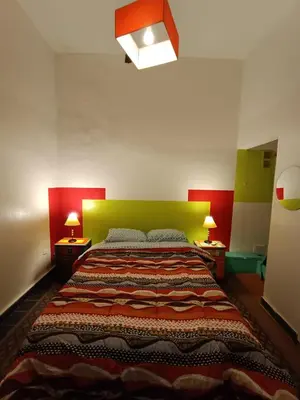 a bedroom with a large bed with a green headboard at Morada Hostel & Bar in Cordoba