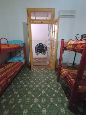 a room with two bunk beds and a door at Morada Hostel & Bar in Cordoba