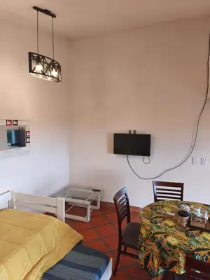 a room with a bed and a table and a tv at Cabañas Akumali in Nono