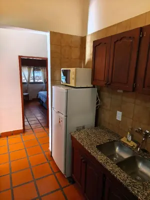 a kitchen with a white refrigerator and a sink at Cabañas Akumali in Nono