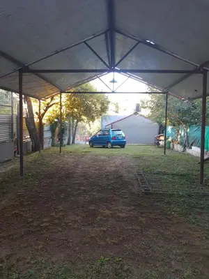 a blue car parked under a tent in a yard at Terraza Perito Moreno in Villa Carlos Paz