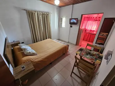 a bedroom with a bed and a table and a window at Terraza Perito Moreno in Villa Carlos Paz