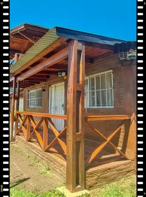 a wooden building with a gate and a house at Cabaña en las Sierras, Sierras Rio Sol!!! Espectacular Cabaña Frente al Rio y las Sierras in Santa María