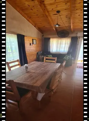 a dining room with a wooden table and chairs at Cabaña en las Sierras, Sierras Rio Sol!!! Espectacular Cabaña Frente al Rio y las Sierras in Santa María