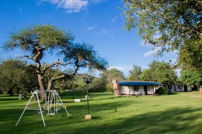 a park with a swing set in the grass at Cabañas Los 2 Algarrobos in Santa Rosa de Calamuchita