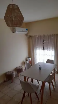 a dining room with a white table and chairs at Excelente departamento en zona céntrica. C/Cochera in Río Cuarto