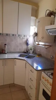 a small kitchen with a sink and a stove at Excelente departamento en zona céntrica. C/Cochera in Río Cuarto