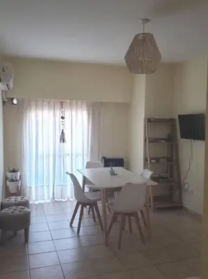 a dining room with a white table and chairs at Excelente departamento en zona céntrica. C/Cochera in Río Cuarto