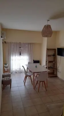 a living room with a table and chairs and a television at Excelente departamento en zona céntrica. C/Cochera in Río Cuarto