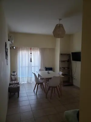 a living room with a table and chairs and a television at Excelente departamento en zona céntrica. C/Cochera in Río Cuarto