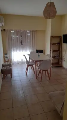 a living room with a table and chairs and a window at Excelente departamento en zona céntrica. C/Cochera in Río Cuarto