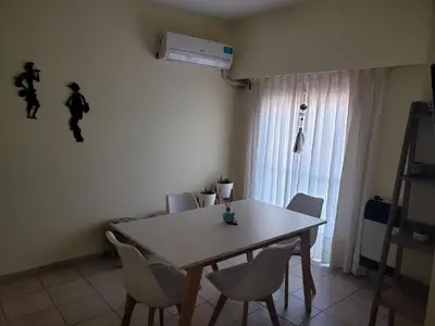 a dining room table and chairs in a room at Excelente departamento en zona céntrica. C/Cochera in Río Cuarto