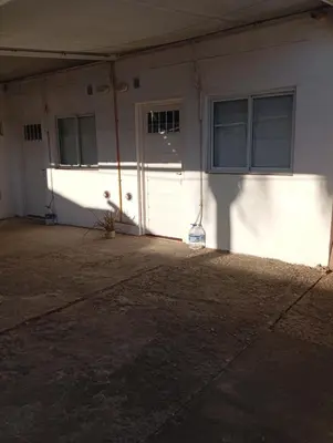 a garage with a white door and a building at Sierras Altas Alojamientos in Villa Carlos Paz