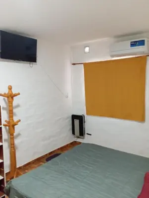 a room with a bed and a tv on a wall at Sierras Altas Alojamientos in Villa Carlos Paz
