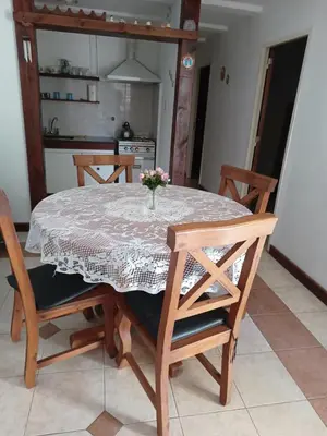 a dining room with a table and chairs and a kitchen at Casita del Río in Santa Rosa de Calamuchita