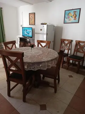 a dining room with a table and chairs and a television at Casita del Río in Santa Rosa de Calamuchita