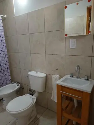 a bathroom with a toilet and a sink at Casita del Río in Santa Rosa de Calamuchita