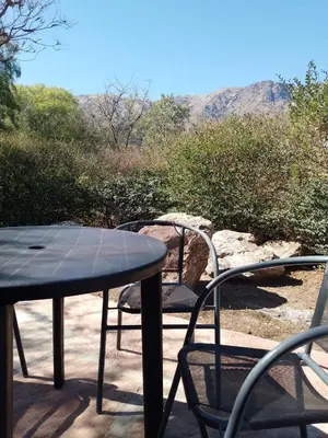 a table and chairs on a patio with mountains in the background at Cabaña La Raquela in La Paz