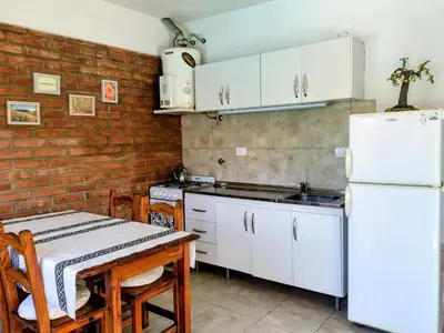 a kitchen with a table and a white refrigerator at Cabaña La Raquela in La Paz