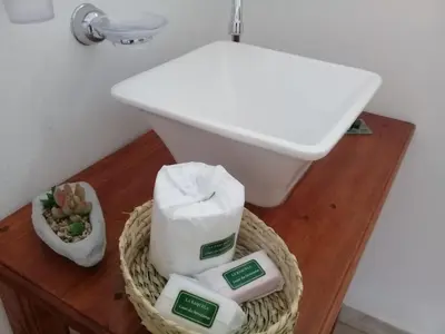 a bathroom with a sink and a basket of toiletries at Cabaña La Raquela in La Paz