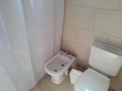 a white bathroom with a toilet and a sink at Cabaña La Raquela in La Paz