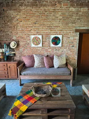 a living room with a couch and a brick wall at Casita de Cuesta in Villa Icho Cruz