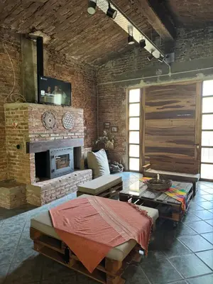 a living room with a brick wall with a fireplace at Casita de Cuesta in Villa Icho Cruz